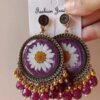 Handmade floral earrings with a real daisy encased in a purple resin frame.